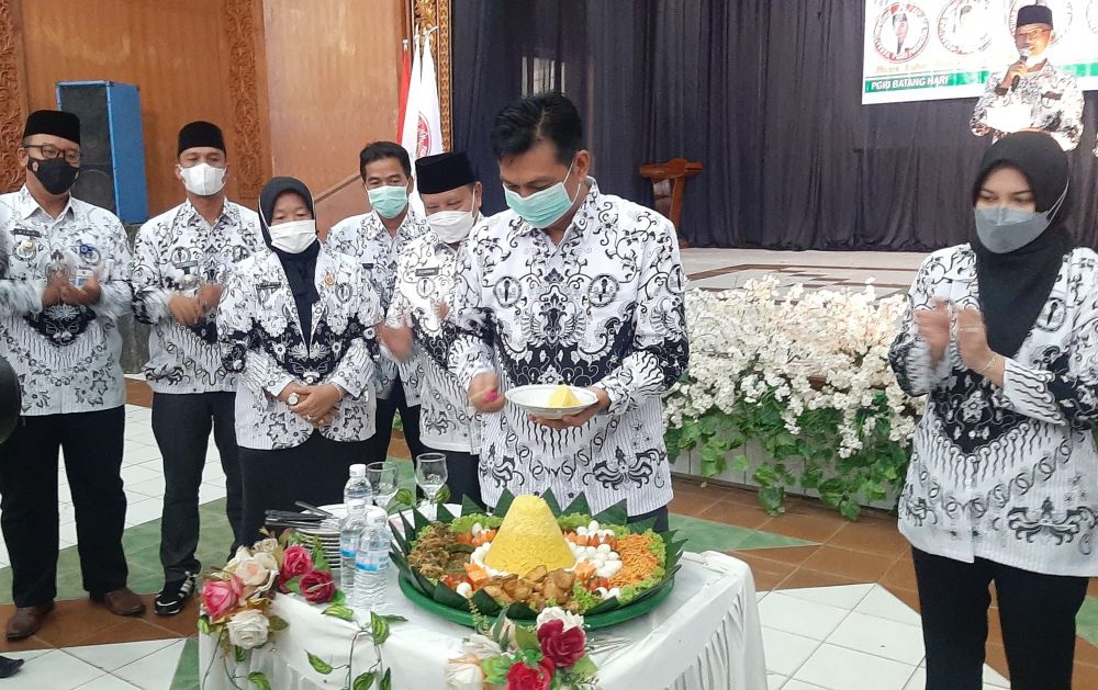 Bupati saat memotong tumpeng dirgahayu PGRI dan HGN ke 76 Kabupaten Batanghari.
